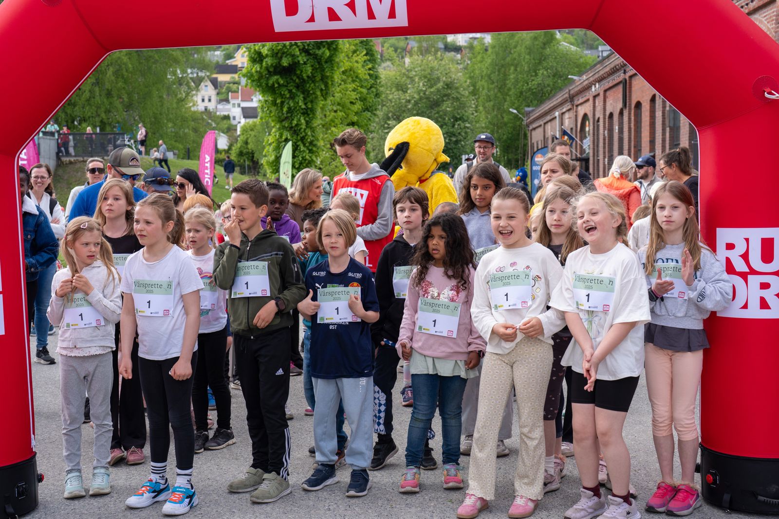 Mange barn smiler på startstreken til et løp