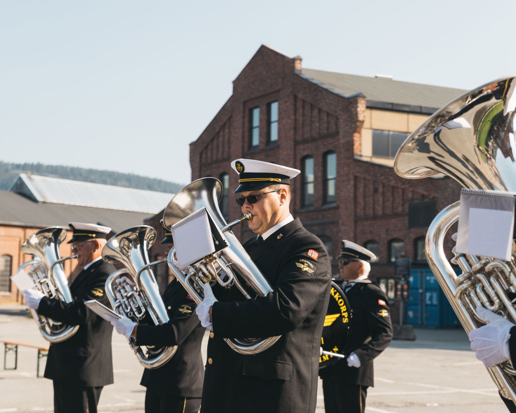 Medlemmer fra korps spiller på blåseinstrument