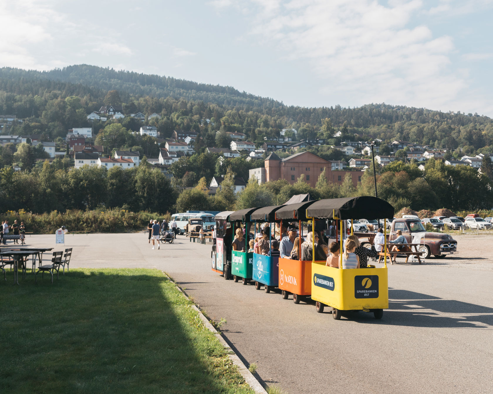 Et fargerikt minitog for barn kjører på en åpen plass
